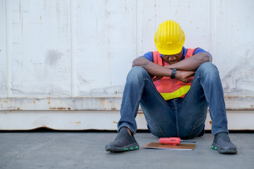 American African engineer or factory worker man sit close to cargo container